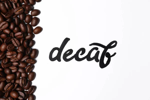 Woord Decaf Koffiebonen Witte Achtergrond Bovenaanzicht — Stockfoto