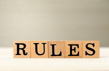 Word Rules made of cubes with letters on light wooden table