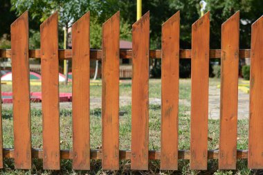 Güneşli bir günde mini golf kortunun yanındaki ahşap çit, yakın plan.