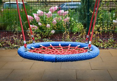 Açık mavi yuva yerleşim alanındaki oyun alanında sallanıyor