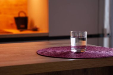 Mutfaktaki ahşap masada bir bardak su. Metin için boşluk