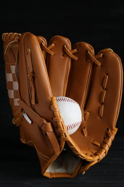 Catcher\'s mitt and baseball ball on black background. Sports game