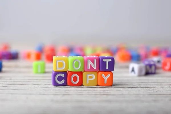 stock image Colorful cubes with words Don't Copy on white wooden table, closeup. Plagiarism concept