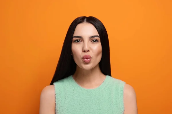 Vacker Ung Kvinna Blåser Kyss Orange Bakgrund — Stockfoto