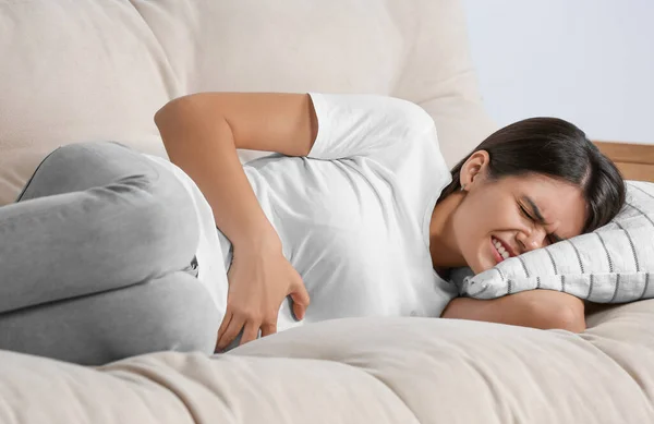 Wanita Muda Yang Menderita Nyeri Menstruasi Sofa Dalam Ruangan — Stok Foto