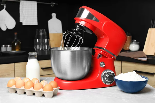 Modern stand mixer and ingredients on table in kitchen. Home appliance