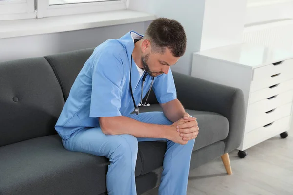 stock image Exhausted doctor sitting on sofa in hospital