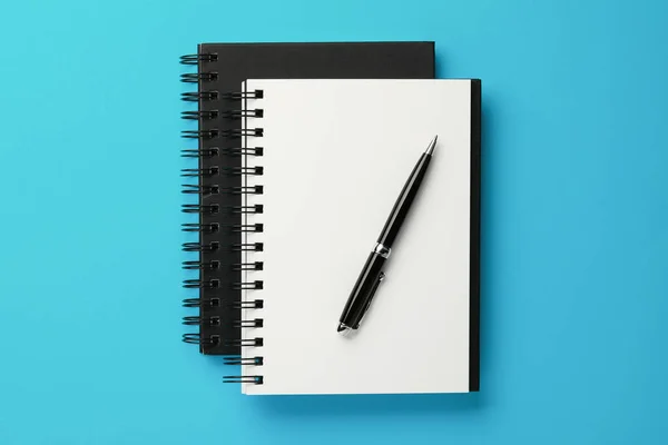 Notebooks Pen Licht Blauwe Achtergrond Bovenaanzicht — Stockfoto