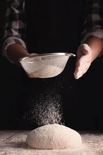 Man Sprinkling Flour Dough Wooden Table Dark Background Closeup — Stock Photo, Image