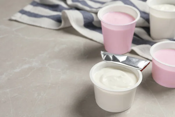 Copos Plástico Com Delicioso Iogurte Orgânico Mesa Mármore Cinza Espaço — Fotografia de Stock