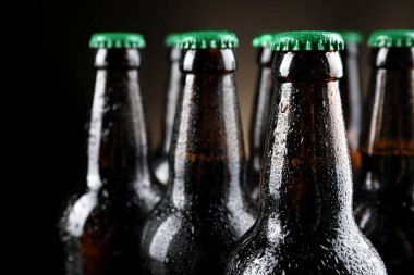 Arka planda bir sürü bira şişesi, yakın plan.