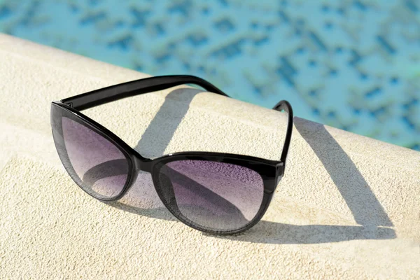 Stylové Sluneční Brýle Blízkosti Venkovního Bazénu Slunečného Dne Detailní Záběr — Stock fotografie