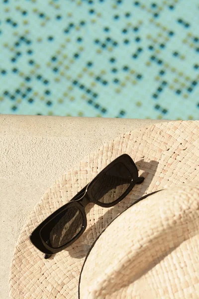Stylowy Kapelusz Okulary Przeciwsłoneczne Pobliżu Odkrytego Basenu Słoneczny Dzień Widok — Zdjęcie stockowe