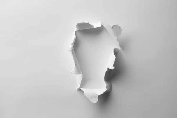 stock image Hole in white paper on light background