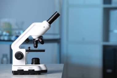 Laboratuvarda gri masada modern tıbbi mikroskop, metin için alan
