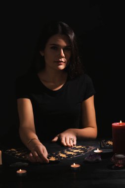 Kahin, karanlıkta tarot kartlarıyla geleceği tahmin ediyor.