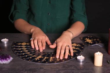 Kahin, karanlıkta tarot kartlarıyla geleceği tahmin ediyor. Yakın plan.