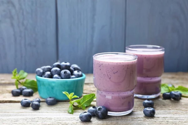 stock image Freshly made blueberry smoothie on wooden table. Space for text