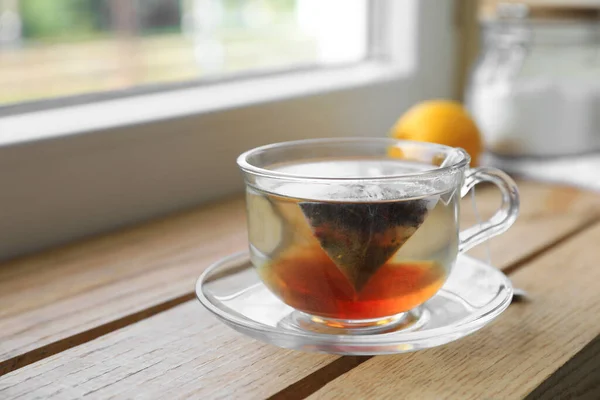 Beutel Mit Schwarzem Tee Tasse Mit Heißem Wasser Auf Holztisch — Stockfoto