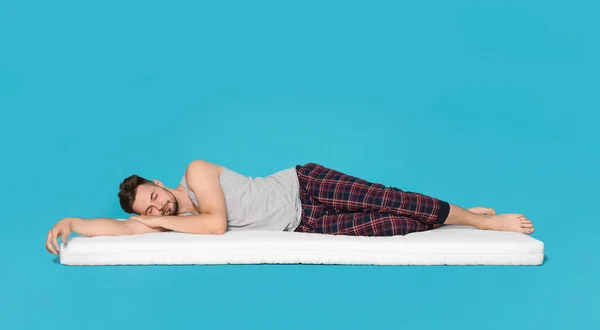 Homem Dormindo Colchão Macio Contra Fundo Azul Claro — Fotografia de Stock