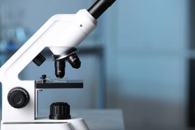 Bulanık arka plana karşı modern tıbbi mikroskop, yakın plan. Metin için boşluk