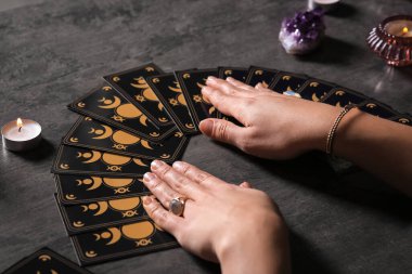 Kahin, masada tarot kartlarıyla geleceği tahmin ediyor. Yakın plan.