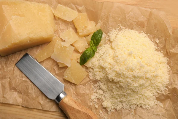 stock image Delicious parmesan cheese on parchment paper, flat lay