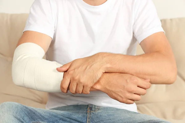 Man Med Arm Insvept Medicinskt Bandage Soffan Närbild — Stockfoto