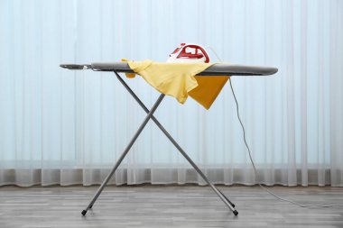 Modern demir ve temiz gömlek kapalı alanda ışık perdelerinin yanında.