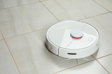 Beyaz fayanslı zeminde robotik süpürge, metin için boşluk