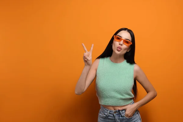 Schöne Junge Frau Mit Stylischer Sonnenbrille Weht Kuss Auf Orangefarbenem — Stockfoto