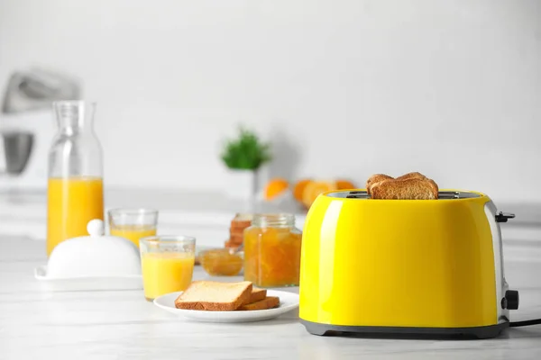 黄色烤面包机 烤面包片 果酱和果汁杯放在白色大理石桌子上 — 图库照片