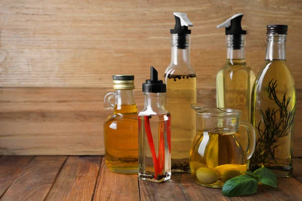 stock image Many different cooking oils on wooden table, space for text