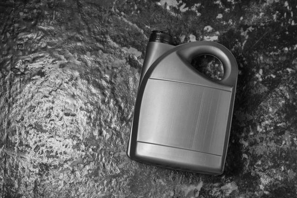 Motor oil in grey canister on black table, top view. Space for text