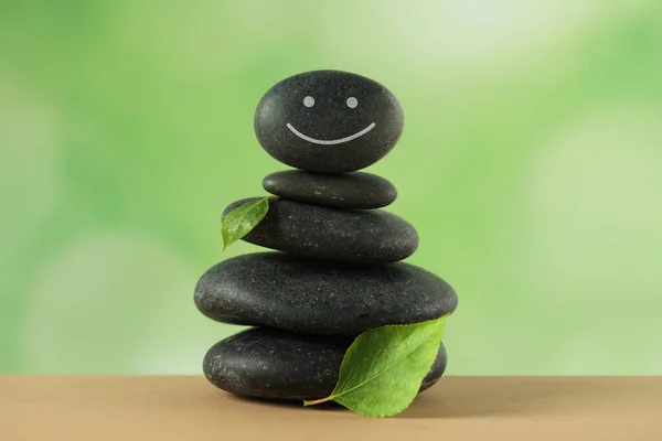 Stapel Von Steinen Mit Gezeichnetem Glücklichen Gesicht Und Grünen Blättern — Stockfoto