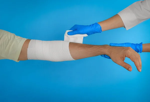 Médico Aplicando Bandagem Médica Mão Paciente Fundo Azul Claro Close — Fotografia de Stock