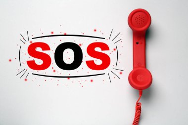 Açık gri arka planda telefon ahizesi, üst görüş. Acil SOS çağrısı