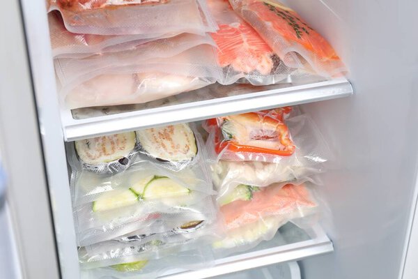 Vacuum bags with different products in fridge. Food storage