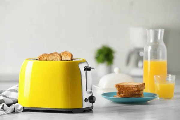 Gelber Toaster Mit Gerösteten Brotscheiben Und Orangensaft Auf Weißem Marmortisch — Stockfoto