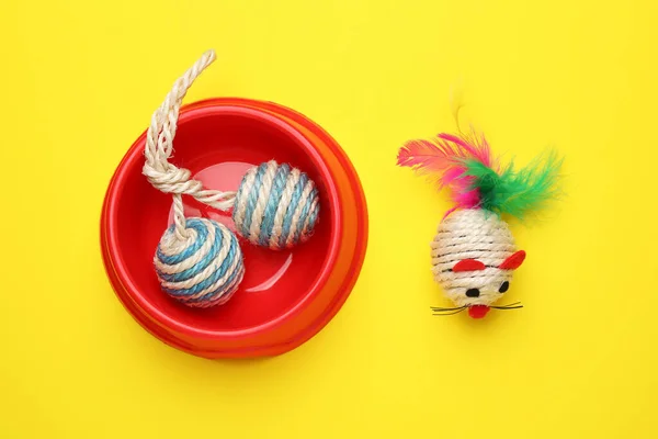 黄色の背景にペットのおもちゃとボウル フラットレイ — ストック写真