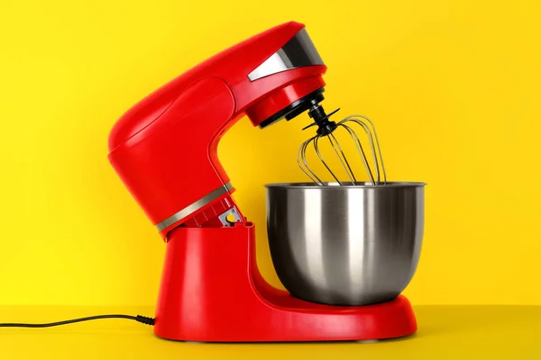 Modern red stand mixer on yellow background