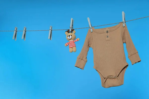 Baby Onesie Medvěd Hračka Sušení Prádelně Světle Modrém Pozadí Prostor — Stock fotografie