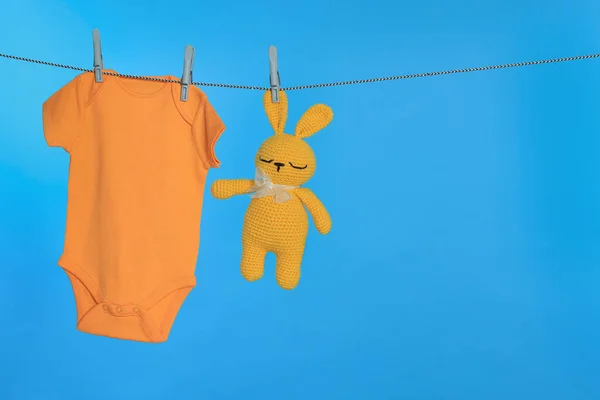 宝宝和兔子玩具在淡蓝色背景的洗衣线上烘干 文字空间 — 图库照片