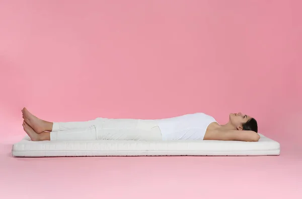 Молодая Женщина Лежит Мягком Матрасе Розовом Фоне — стоковое фото