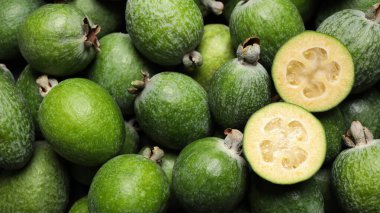 Arka plan olarak taze yeşil feijoa meyveleri, yakın plan. Pankart tasarımı