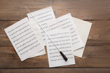 Orkestra şefinin sopası ve notaları ahşap masada, düz yatıyordu.