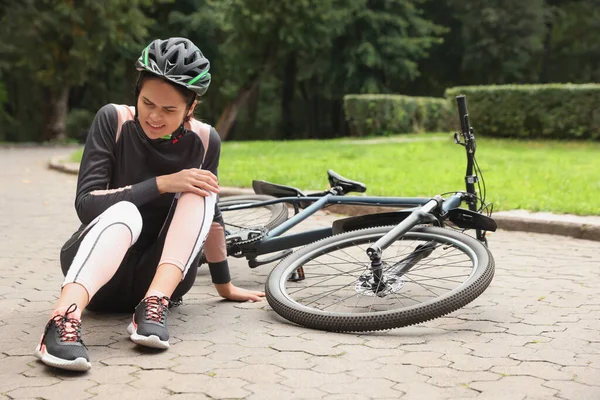 Mujer Joven Con Rodilla Lesionada Cerca Bicicleta Aire Libre — Foto de Stock