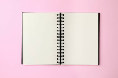 Blank notebook on pale pink background, top view