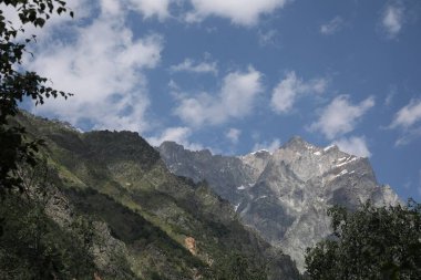 Bulutlu gökyüzünün altındaki dağların resimli görüntüsü