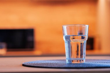 Mutfaktaki ahşap masada bir bardak su. Metin için boşluk